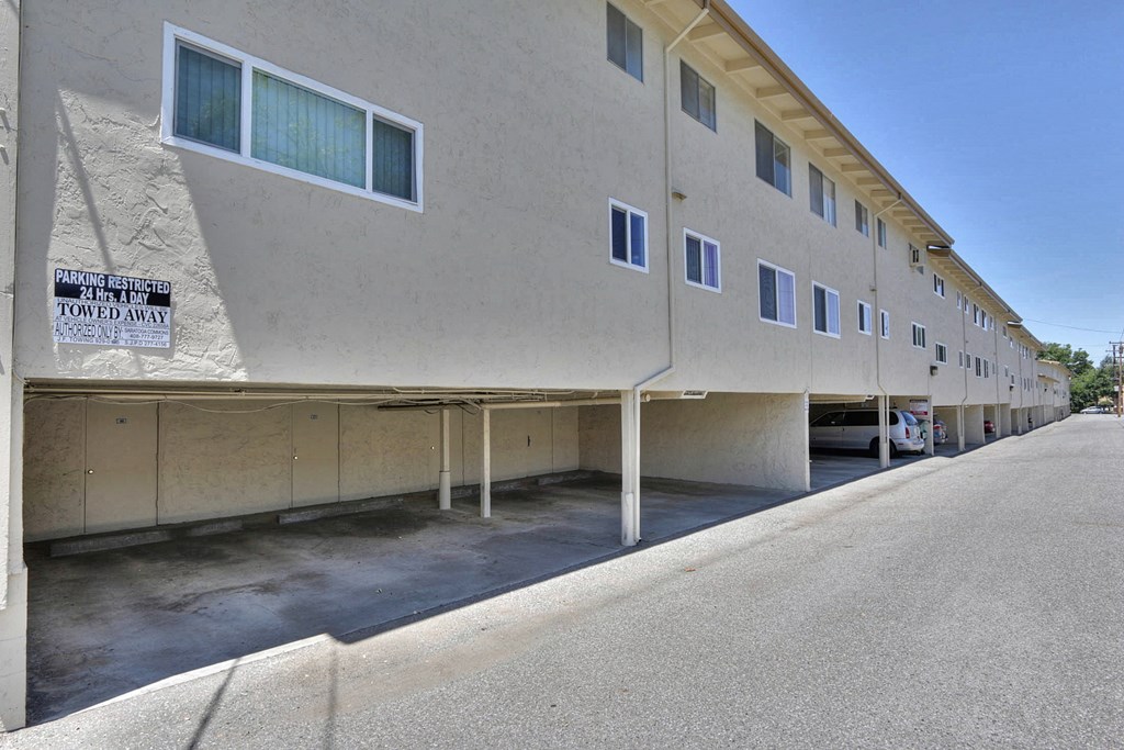 A parking sign on a building warns that vehicles will be towed if parked there.