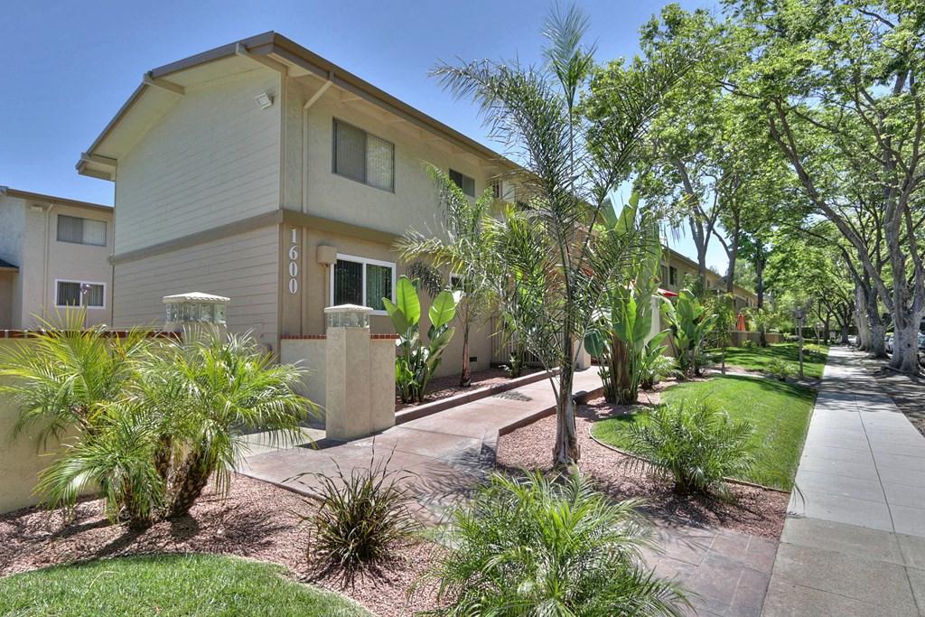 A sunny day at a residential area with houses and greenery.