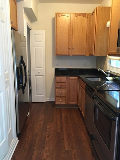 A kitchen with wooden cabinets and a black stove top oven.