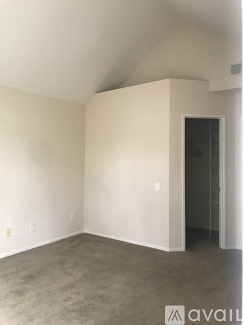 A spacious room with a carpeted floor and white walls.