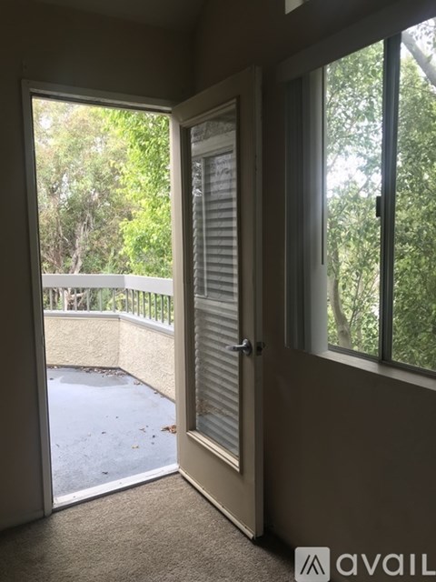 A room with a sliding door leading to a balcony.