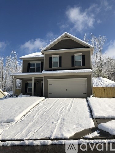 A house with a garage is surrounded by snow.