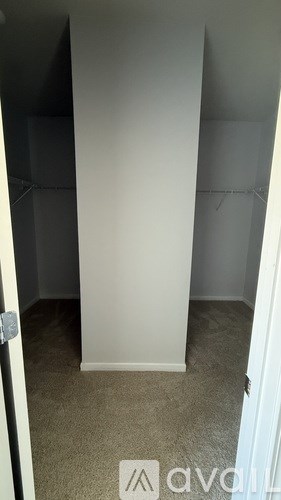 A small, empty room with a carpeted floor and white walls.