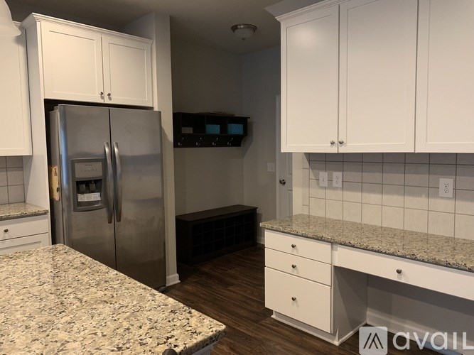 A kitchen with white cabinets and a granite countertop.