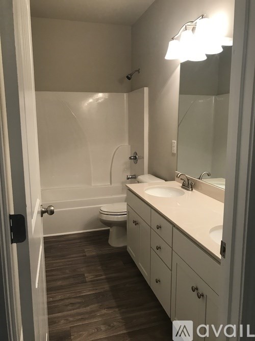 A bathroom with a toilet, sink, and mirror.