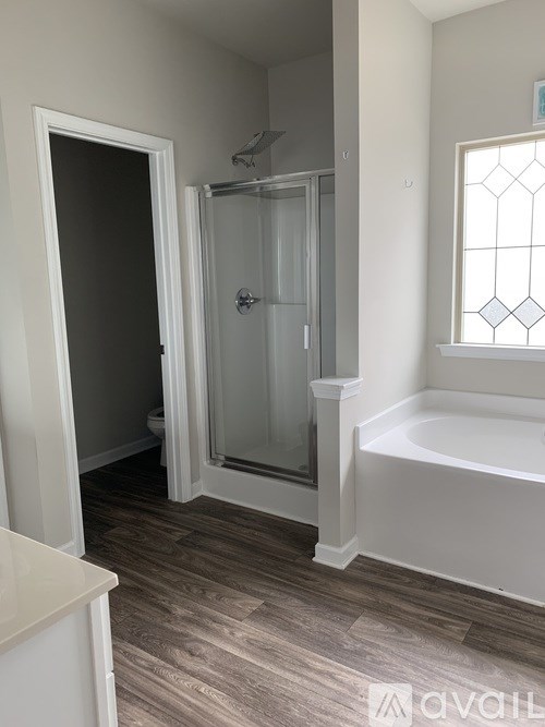 A bathroom with a glass shower door and a bathtub.