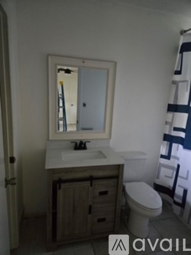 A bathroom with a sink, mirror, and toilet.