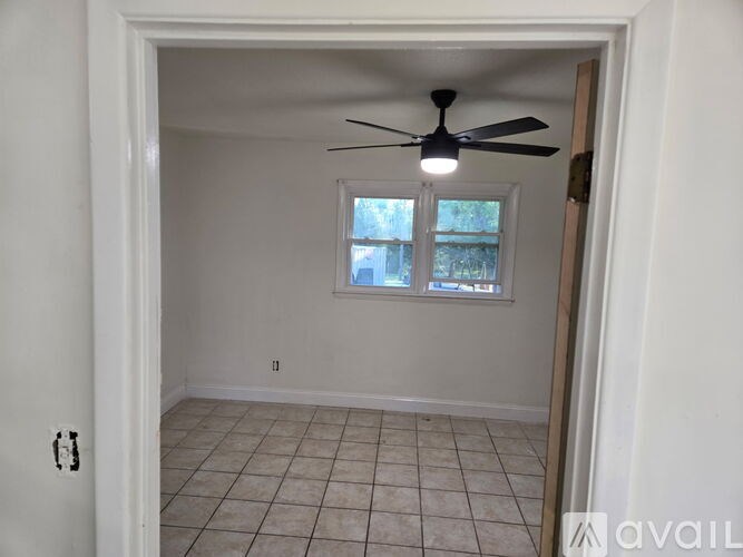 A room with a ceiling fan and a window.
