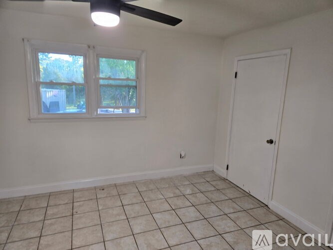 A room with a ceiling fan and a door.