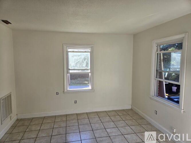 A room with a window and tiled floor.