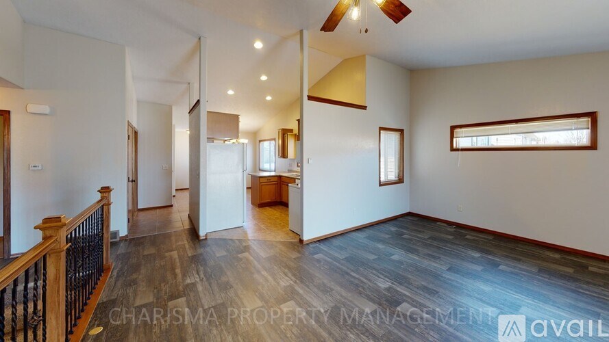A spacious living room with a staircase on the left side.