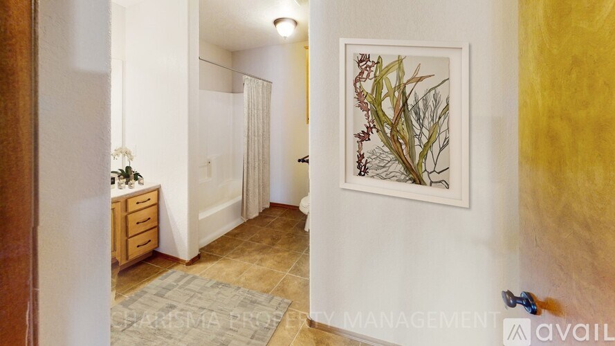 A hallway with a framed picture on the wall and a rug on the floor.
