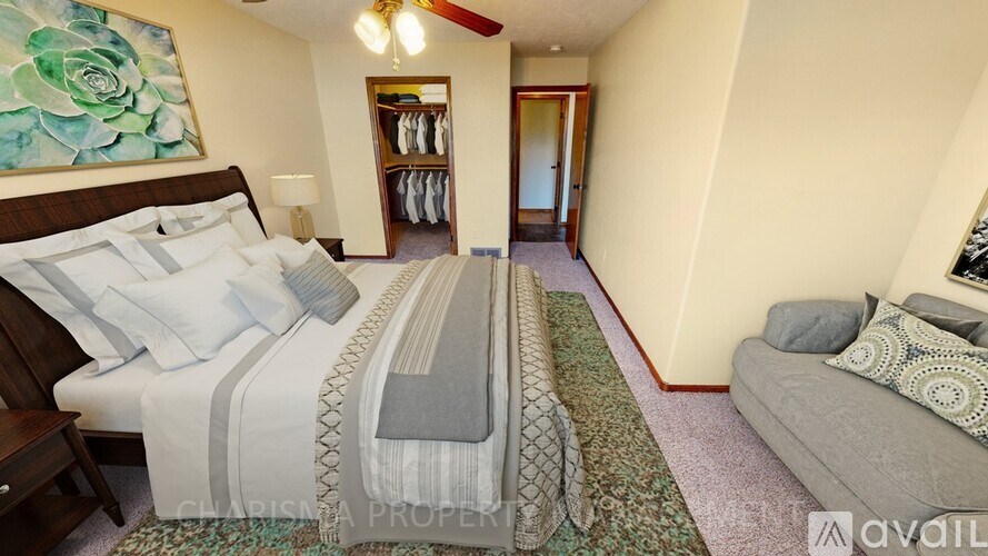 A bedroom with a large bed and a couch.