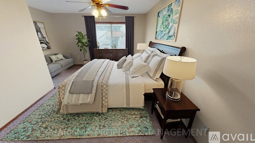 A well-lit bedroom with a large bed and a ceiling fan.