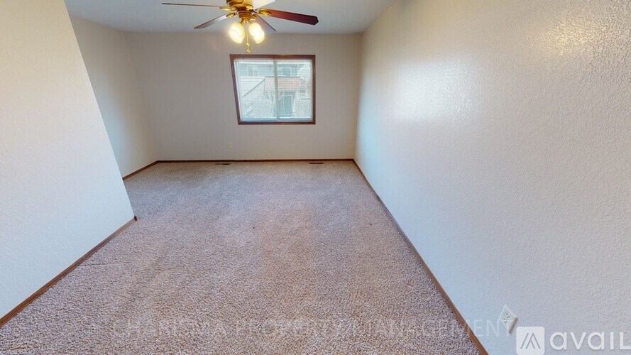A room with a ceiling fan and a window.