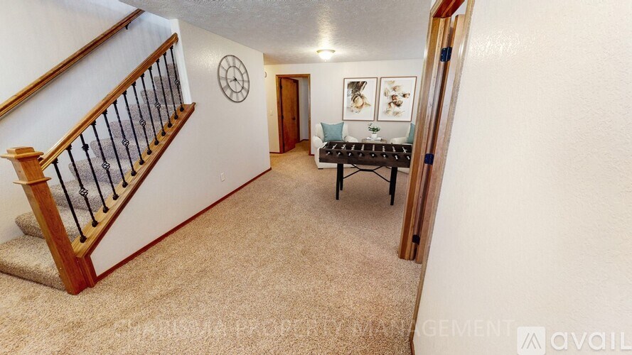 A living room with a couch, a coffee table, and a staircase.