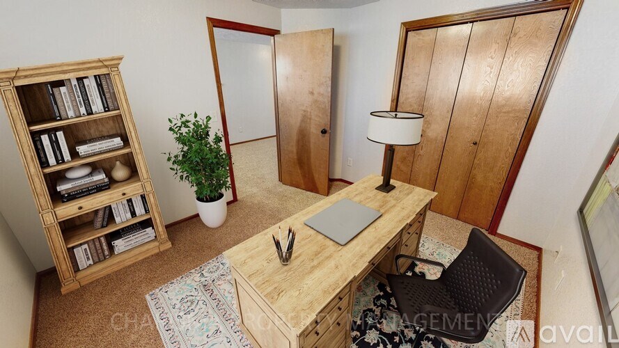A room with a desk, chair, and bookshelf.