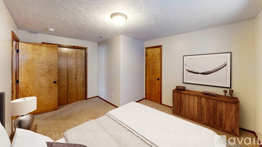 A bedroom with a bed, nightstand, and two doors.