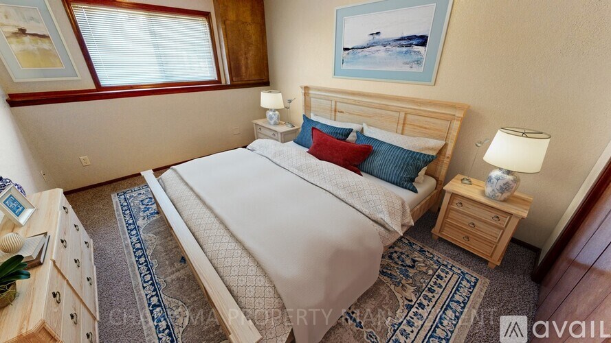 A bedroom with a large bed, a nightstand, and a rug.