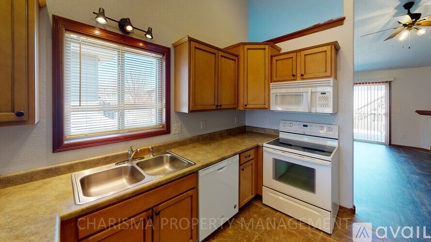 A kitchen with wooden cabinets and white appliances.