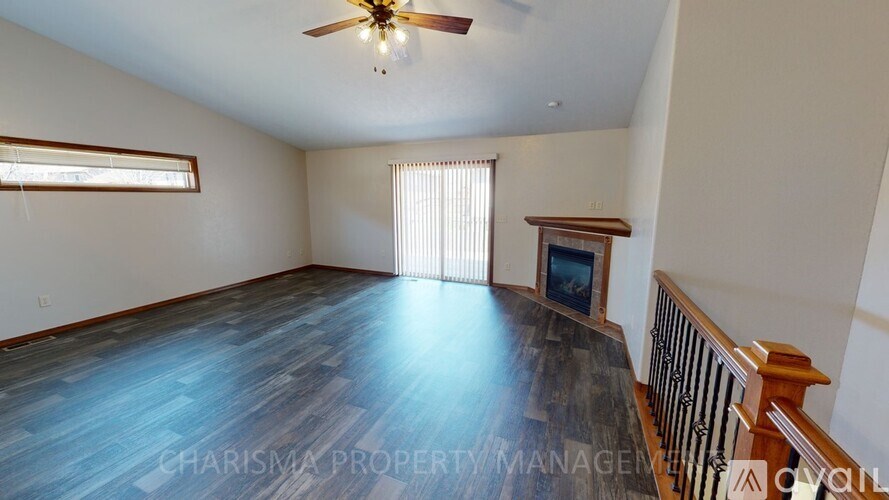 A spacious room with a ceiling fan and a window with blinds.