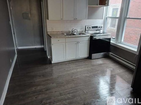 A kitchen with white cabinets and a black countertop.