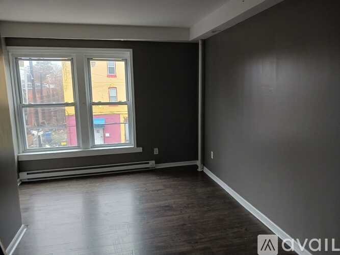 A room with a window showing a view of a building.