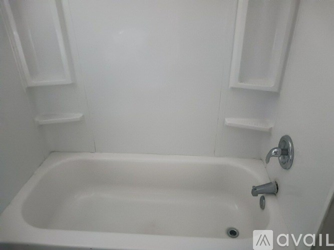 A white bathtub with a silver faucet and a small drain.