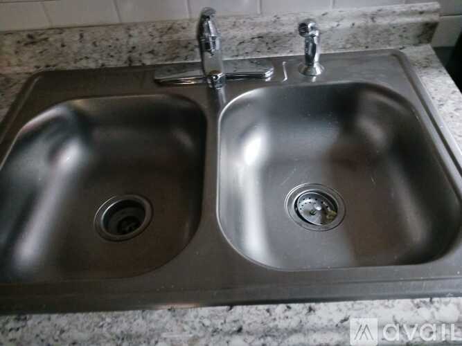 A double stainless steel sink with two faucets.