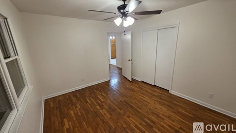 A room with wooden flooring and a ceiling fan.