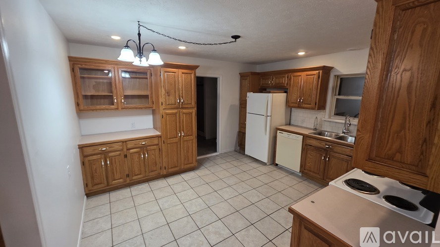 A kitchen with wooden cabinets and a white refrigerator.