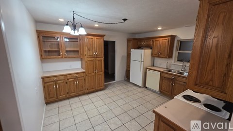 A kitchen with wooden cabinets and a white refrigerator.