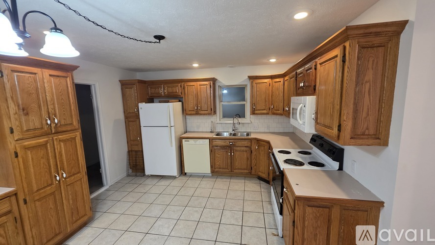 A kitchen with wooden cabinets and white appliances.