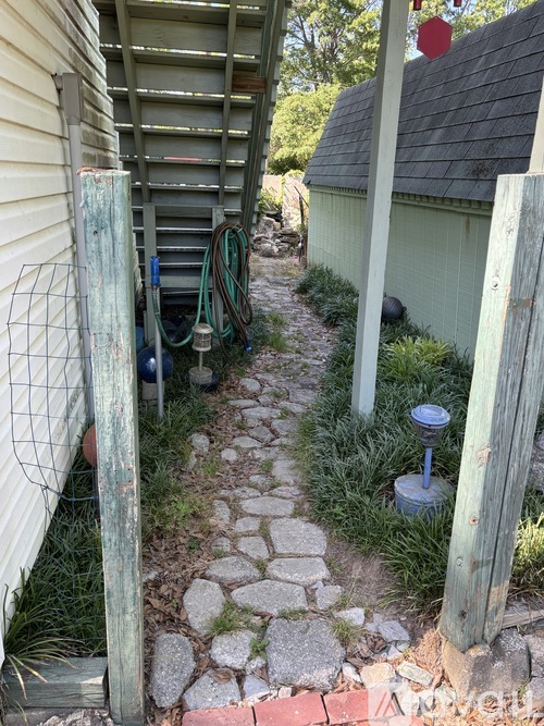 A narrow stone pathway leads through a garden.