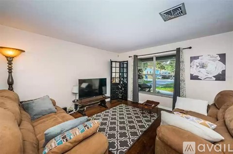 A living room with a brown couch and a television.