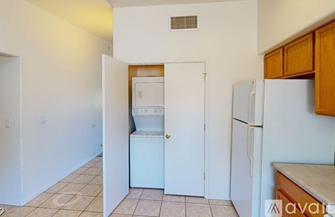 A kitchen with a white refrigerator and a white washing machine.