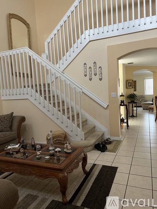 A living room with a staircase and a coffee table.