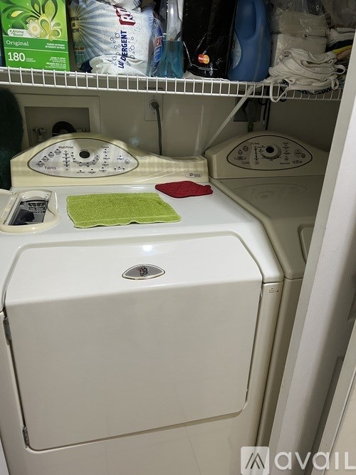 A white washing machine with a green mat on top.