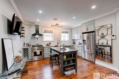 A kitchen with a wooden table and stainless steel appliances.