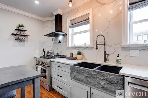A kitchen with a marble countertop and a sink.