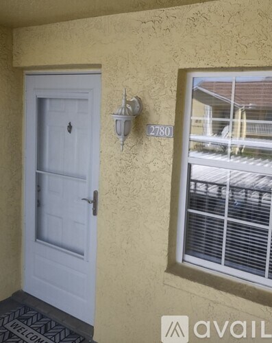 A white door with a black and white patterned mat in front of it.