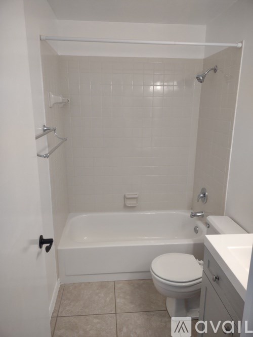 A white bathroom with a toilet, sink, and bathtub.