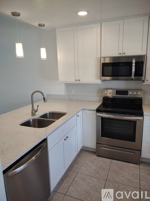 A kitchen with white cabinets and a stainless steel oven.