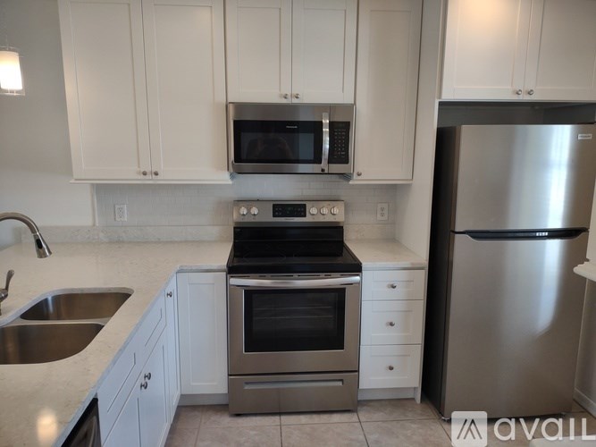 A kitchen with white cabinets and stainless steel appliances.