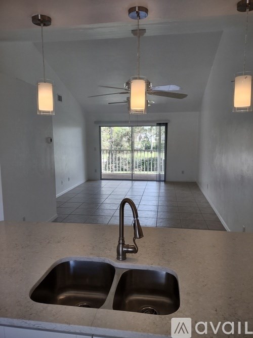 A kitchen with a sink and a ceiling fan.
