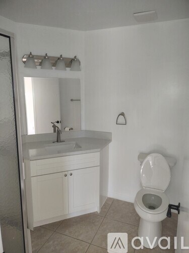 A white toilet sits next to a sink in a bathroom.