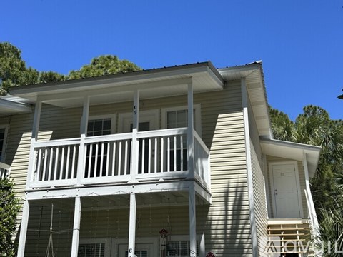 A two-story house with a balcony and a door.