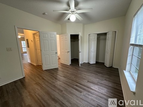 A room with a ceiling fan and wooden flooring.
