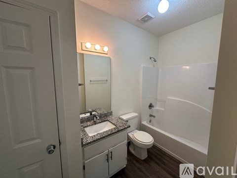 A bathroom with a toilet, sink, and mirror.