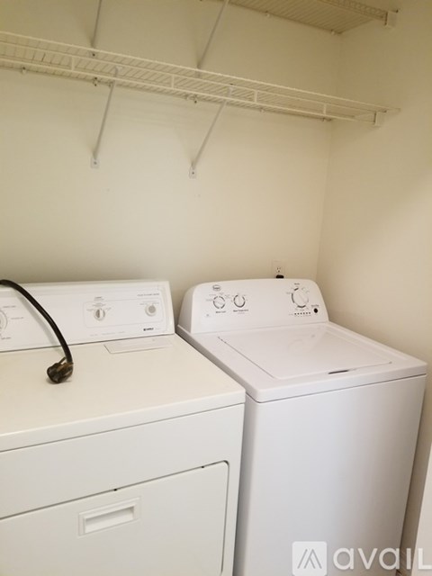 Two white front loading washing machines in a laundry room.